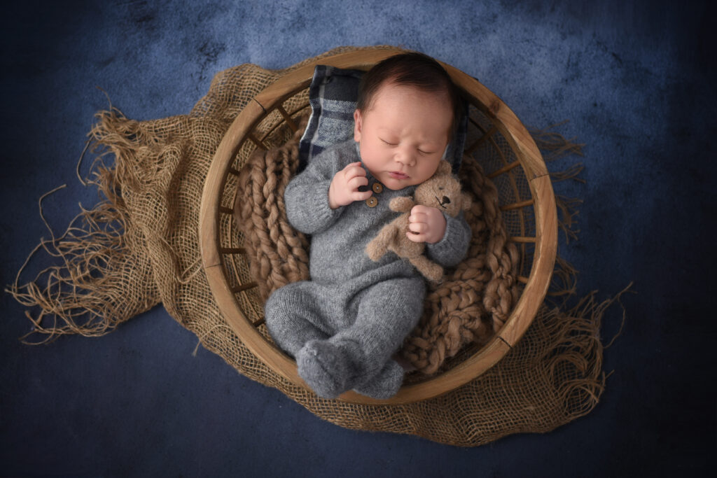 Newborn baby boy Noah  in grey outfit during studio newborn session in Wallingford, Connecticut